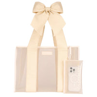 The Raffia Bow Jelly Tote Bag W/ Phone Pouch is a beige transparent resort tote with wide handles tied in a bow, paired with a matching pouch holding a white phone case.